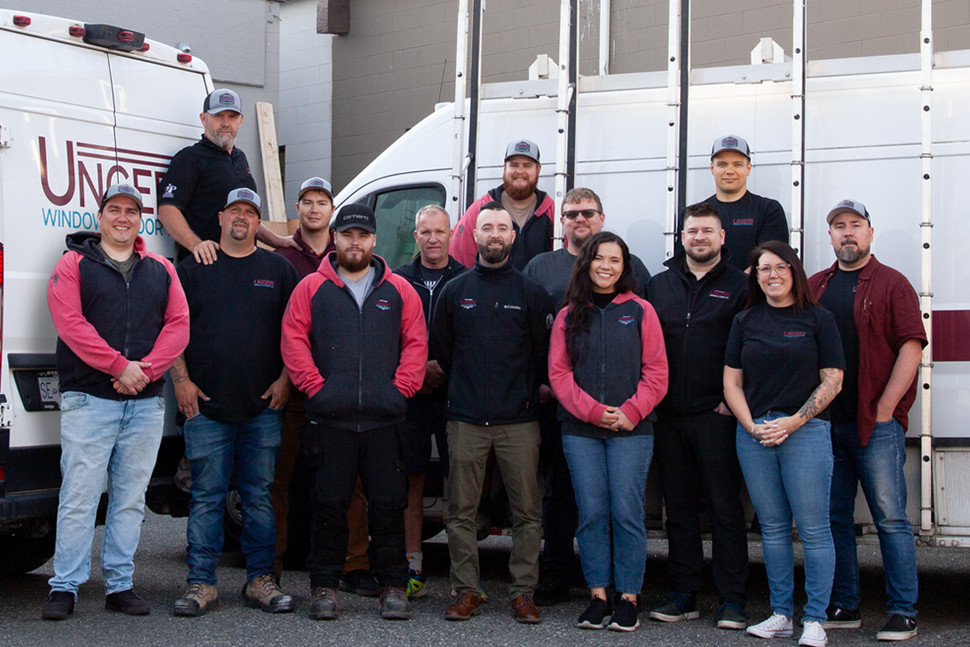 The Unger Window & Door professional installation team standing together in front of company service vehicles.