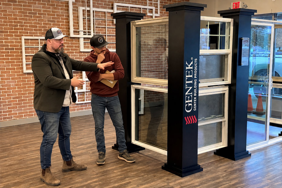 Window specialist explaining product options and factors affecting average window replacement cost to a customer in a showroom.