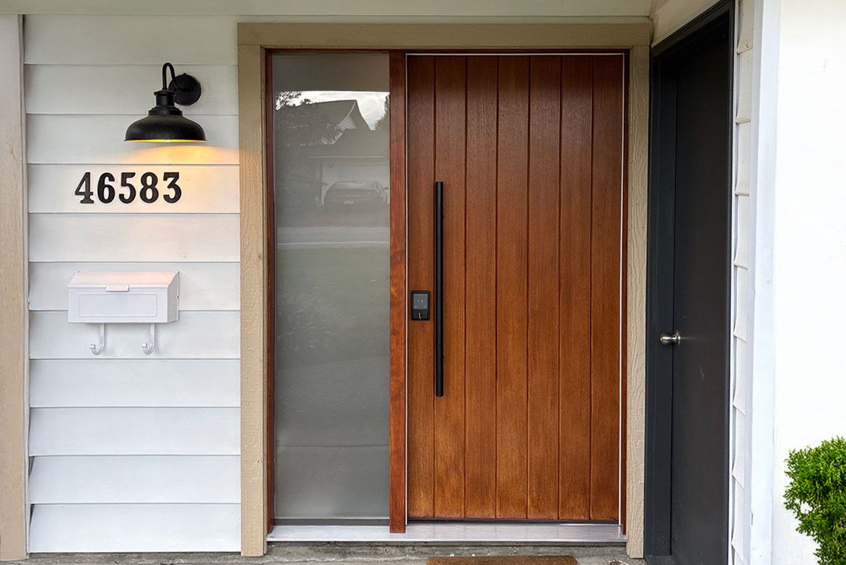 Stylish modern wood front door with frosted side glass panel and long vertical handle.