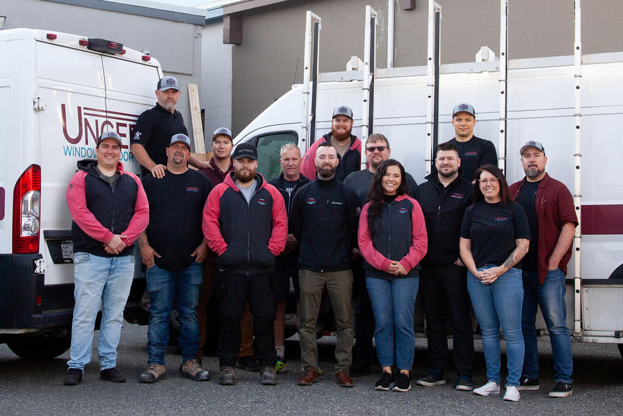 Unger Window & Door installation team standing together in front of company service vans.